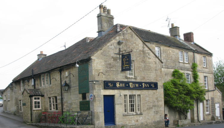 The New Inn pub in Westwood village, a traditional Cotswold stone building at a quiet rural crossroads