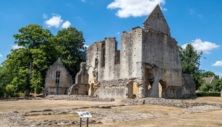 Ruins of Minster Lovell Hall beside the River Windrush with historic stone walls and open green grounds