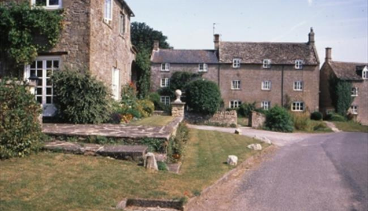 Stone cottages and a quiet country lane in Fulbrook village near Burford in the Cotswolds