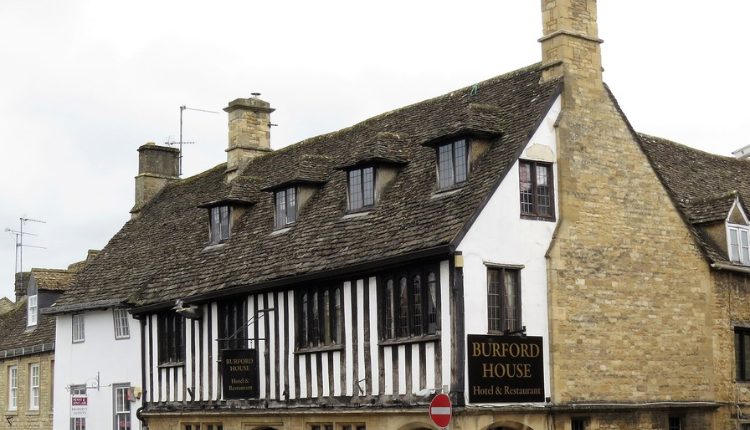 Exterior of Burford House Hotel in Burford, a historic half-timbered Cotswold stone building on a street corner