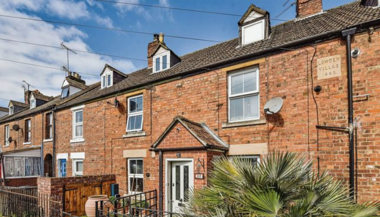 Traditional red-brick Victorian terraced houses on a quiet residential street in Lowden, Chippenham