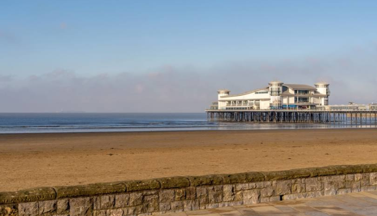 Weston-super-Mare beach with the Grand Pier extending over the sea under a clear sky