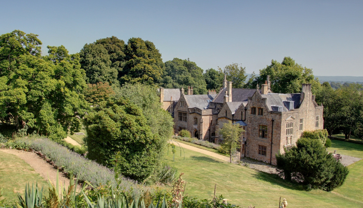 Historic stone manor house surrounded by gardens and trees in the village of Kenn, North Somerset