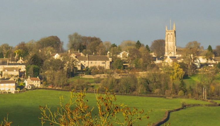 View of Colerne village with St John the Baptist Church tower overlooking green countryside in Wiltshire