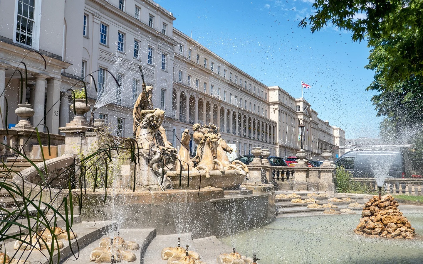Fountain and historic buildings along Cheltenham town centre, ideal for sightseeing and Cheltenham airport transfers.