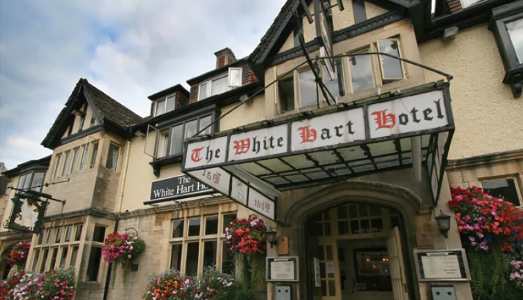 The White Hart Inn in Cricklade, a traditional historic hotel with hanging flower baskets at the entrance.