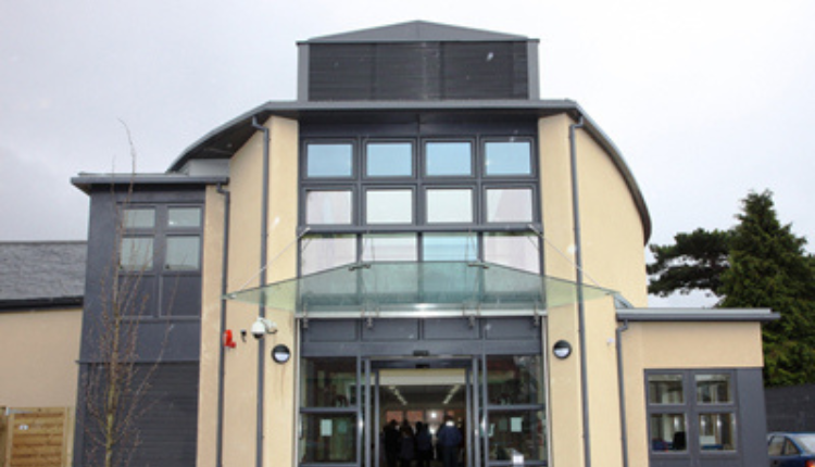 Oaksey House in Oaksey, a modern community building with a curved roof, glass entrance, and contemporary exterior.