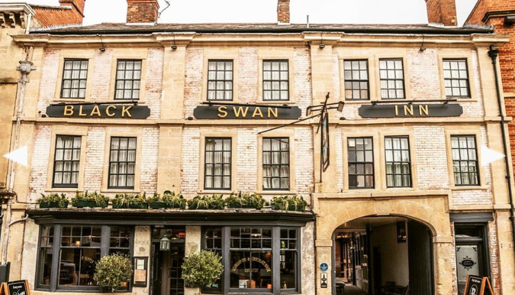 The Black Swan Inn in Devizes, a traditional historic pub with a stone façade and arched passageway
