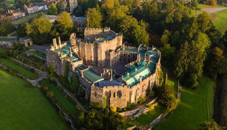 Aerial view of Stinchcombe Castle surrounded by landscaped grounds in Gloucestershire.