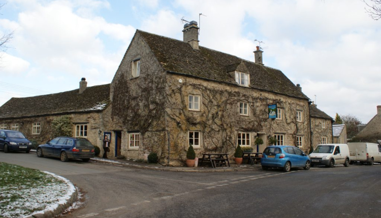 Cotswold stone village building in Southrop with ivy-covered walls.