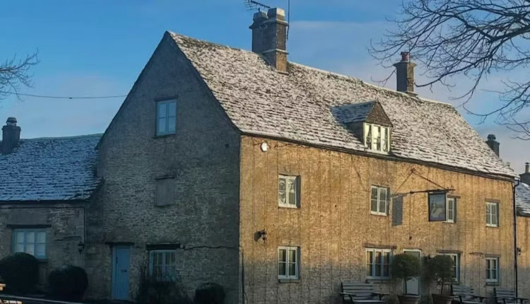 The Swan at Southrop near Faringdon, a traditional Cotswold stone country inn with outdoor seating.