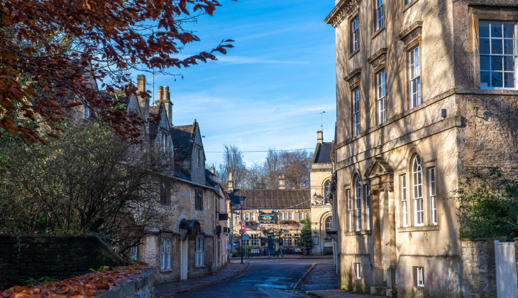 Quiet street in Corsham with historic stone buildings, autumn leaves, and traditional Wiltshire architecture